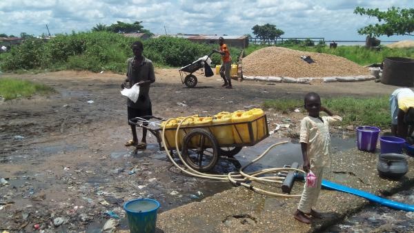 A water vendor in Makurdi, Nigeria fills his cans with water from the polluted Benue River